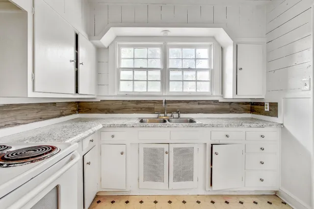a kitchen with granite countertop a sink stove and cabinets