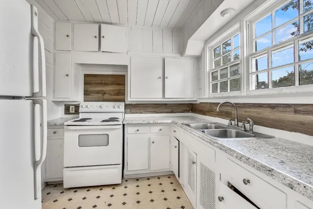 a kitchen with granite countertop a sink stove and cabinets