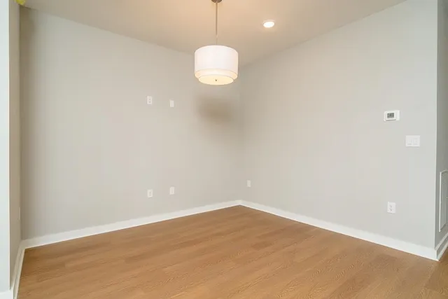 a view of a room with wooden floor and white walls