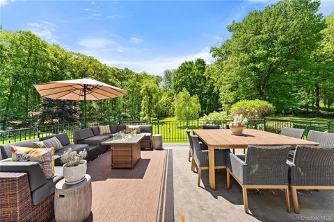a view of a patio with furniture and a backyard