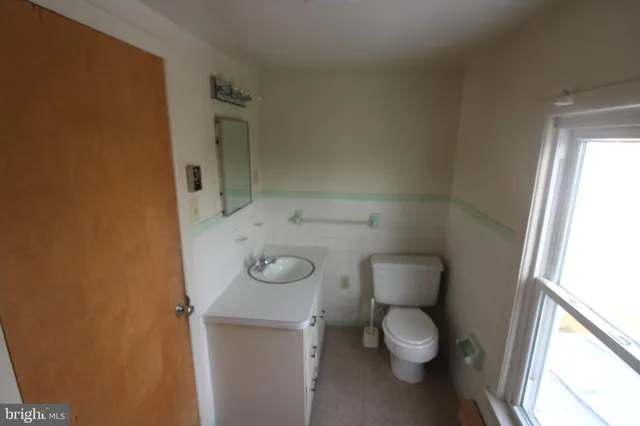 a bathroom with a granite countertop toilet and a sink