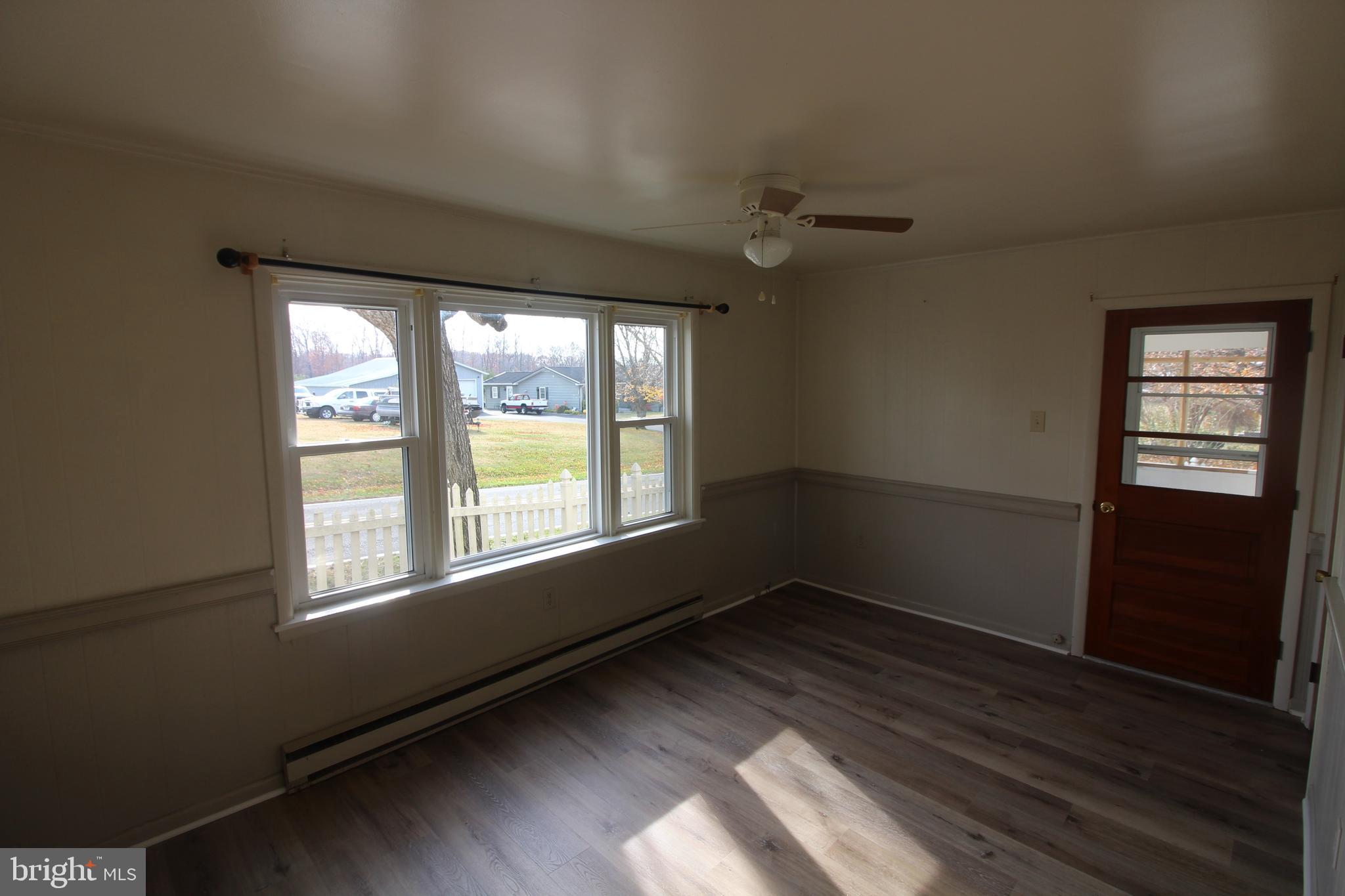 19801 Senedo Road Edinburg, VA 22824 - Photo 2 of 16 an empty room with wooden floor and windows