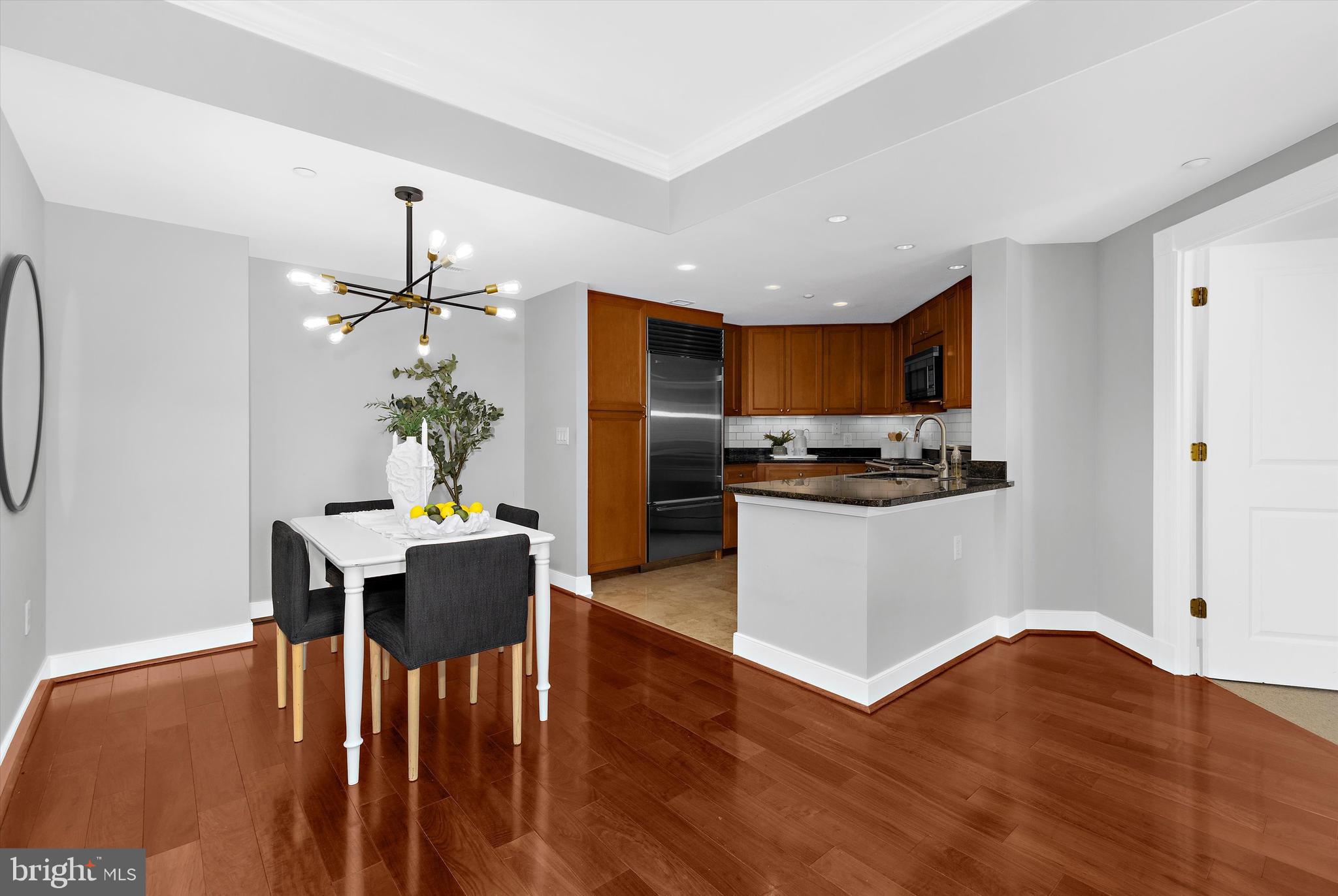 5 Park Place, Unit 702 Annapolis, MD 21401 - Photo 3 of 55 a kitchen with stainless steel appliances kitchen island granite countertop a refrigerator a stove a microwave oven a dining table and chairs with wooden floor