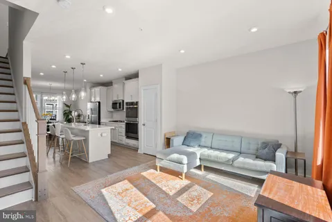 a living room with furniture and a view of kitchen