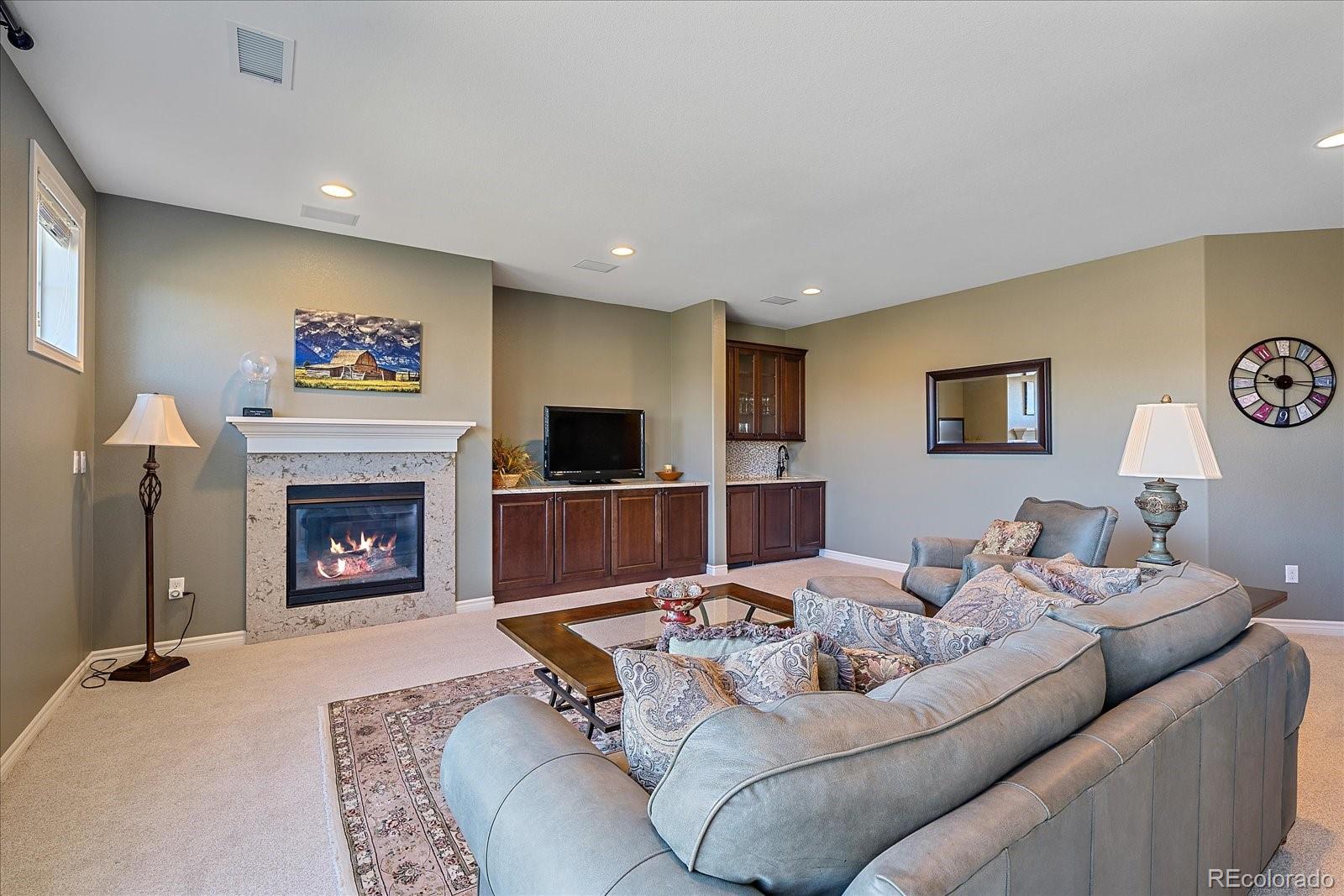 9317 Viaggio Way Highlands Ranch, CO 80126 - Photo 32 of 50 a living room with furniture and a fireplace