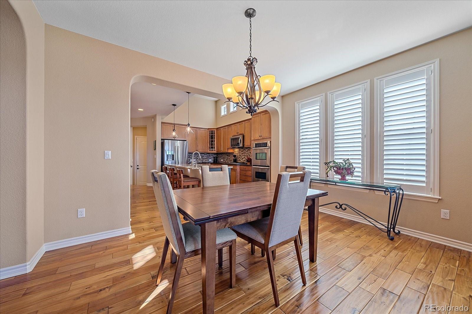 9317 Viaggio Way Highlands Ranch, CO 80126 - Photo 10 of 50 a view of a dining room with furniture window and wooden floor