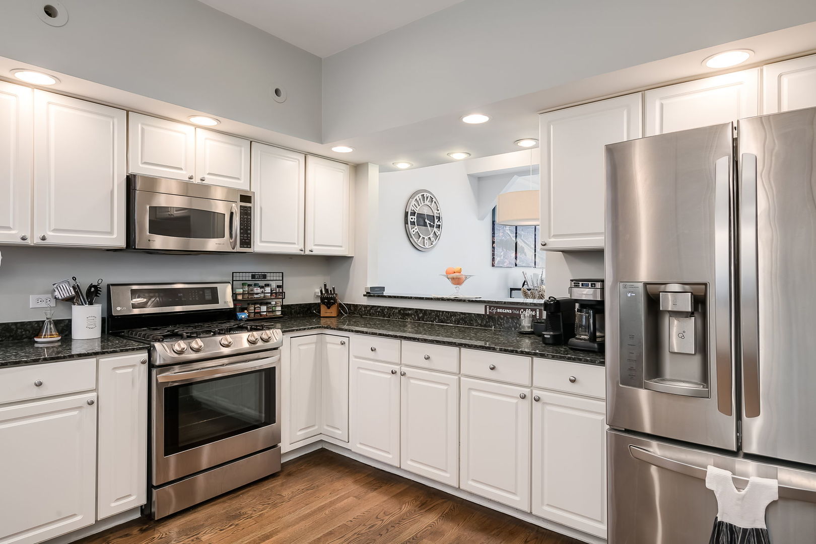 Undisclosed Address Chicago, IL 60657 - Photo 13 of 24 a kitchen with granite countertop white cabinets and stainless steel appliances