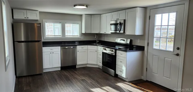 a kitchen with white cabinets and stainless steel appliances