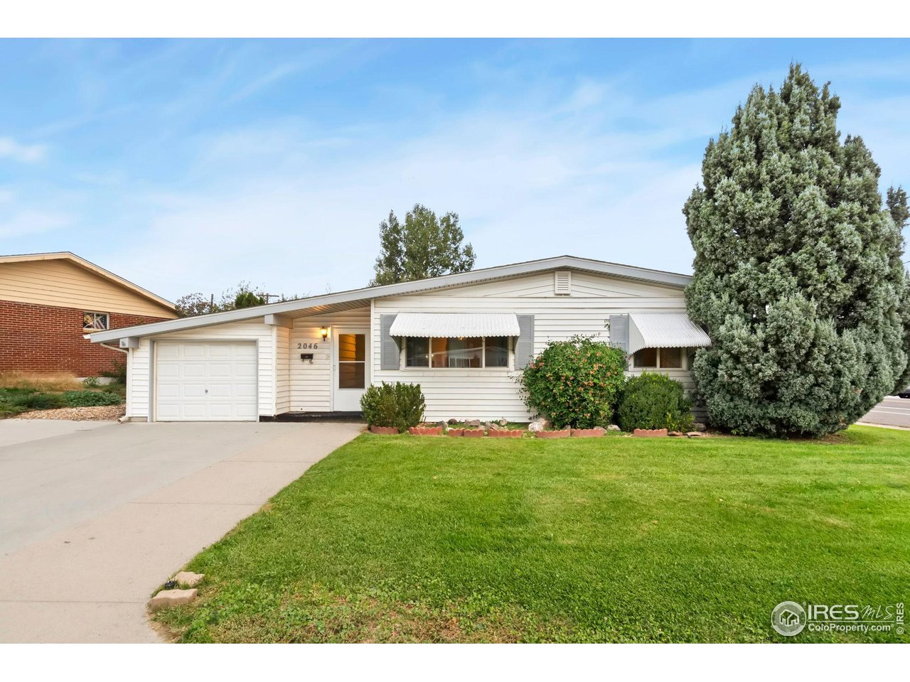 2046 26th Street Road Greeley, CO 80631 - Photo 5 of 34 a front view of a house with a garden and yard