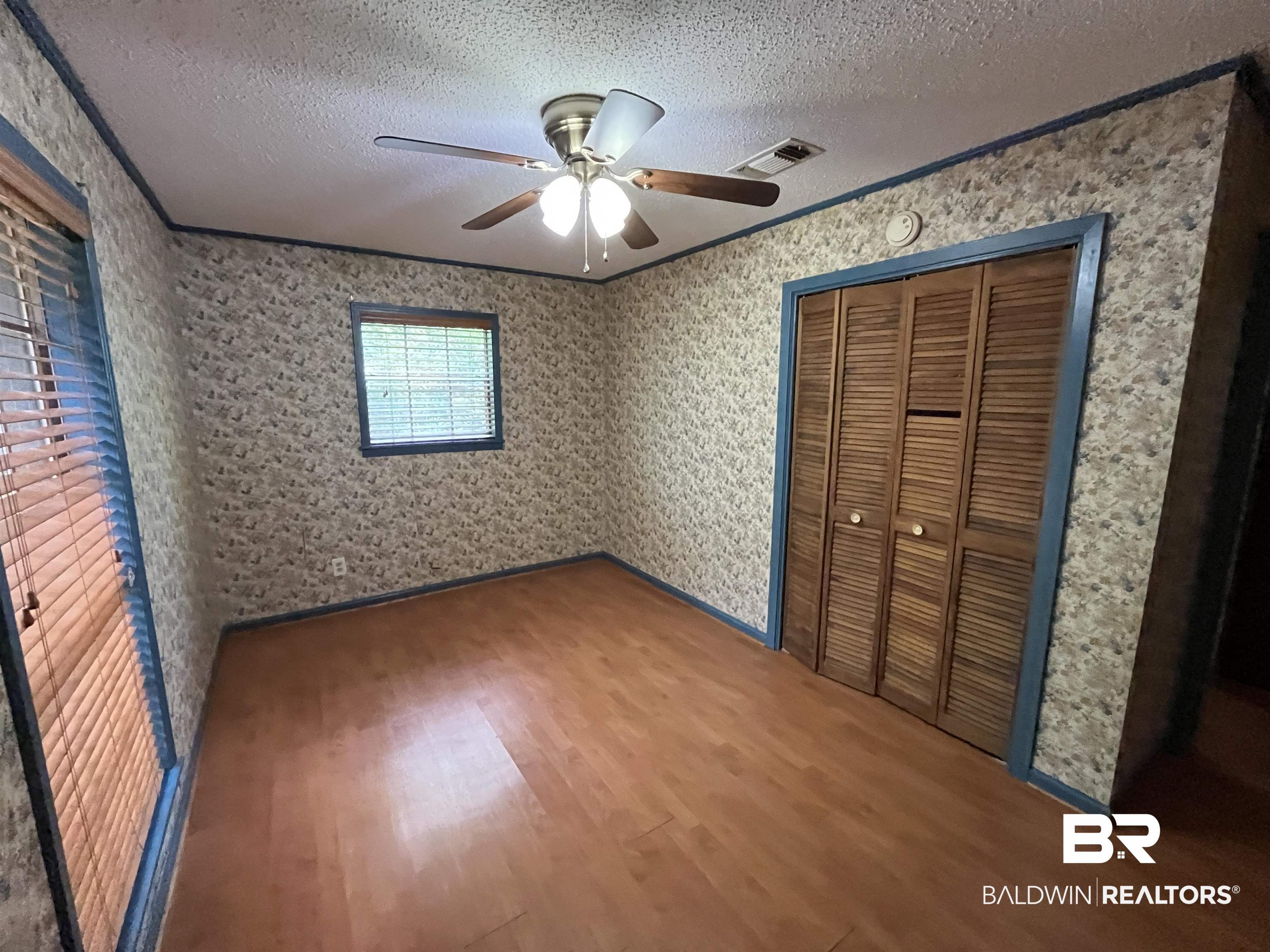 1905 Rockaway Creek Road Atmore, AL 36502 - Photo 22 of 23 Room featuring wood-finish flooring, two windows, and a ceiling fan with integrated lighting