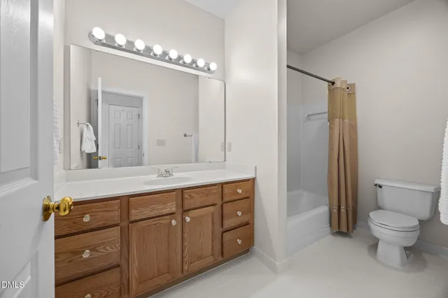 a spacious bathroom with a granite countertop sink a toilet and a mirror