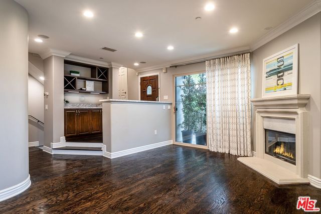 a view of a livingroom with a fireplace wooden floor and window