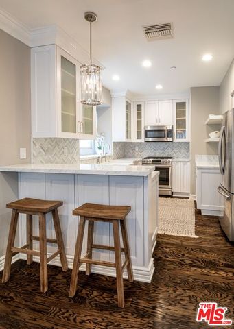 a kitchen with kitchen island granite countertop a stove a sink and a refrigerator