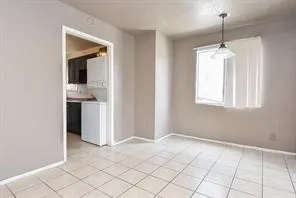 a view of an empty room with window and cabinet