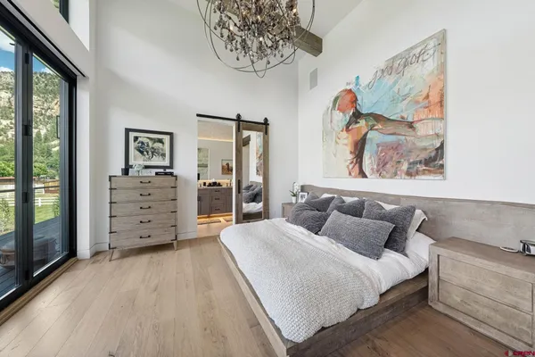 a spacious bedroom with a bed and a painting on the wall