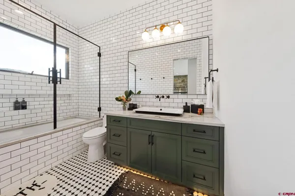 a bathroom with a toilet a sink and mirror