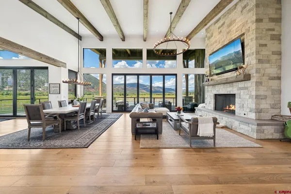 a living room with fireplace furniture and a large window