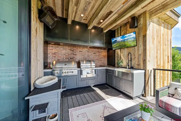 a kitchen with a sink appliances cabinets and a large window