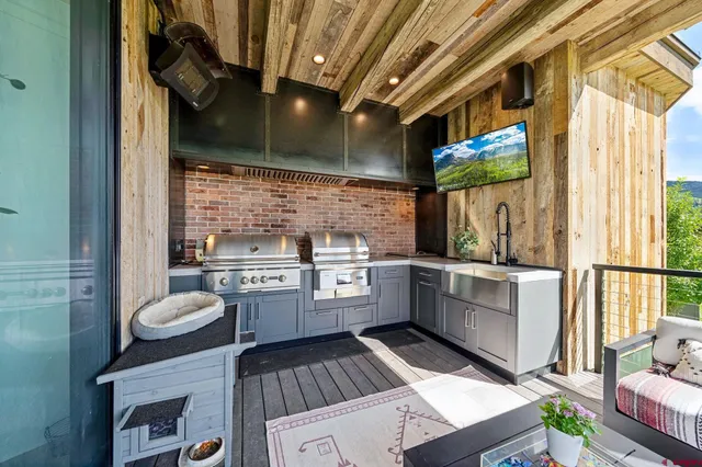 a kitchen with a sink appliances cabinets and a large window