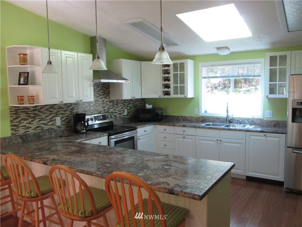 18905 Rouse Road Southwest Longbranch, WA 98351 - Photo 5 of 25 a kitchen with granite countertop a sink a counter top space and cabinets