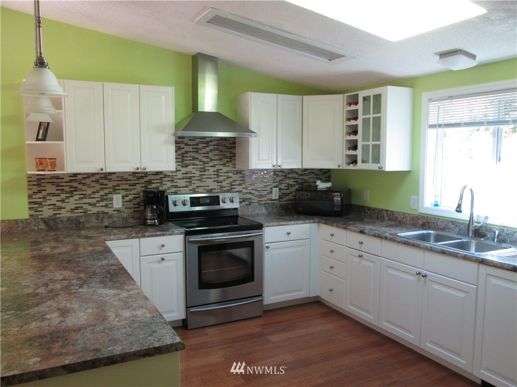 18905 Rouse Road Southwest Longbranch, WA 98351 - Photo 6 of 25 a kitchen with granite countertop a sink a stove a microwave and cabinets