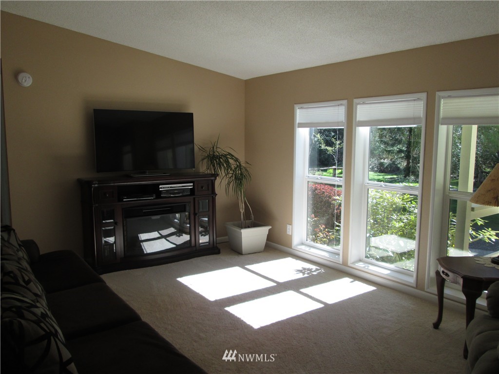 18905 Rouse Road Southwest Longbranch, WA 98351 - Photo 7 of 25 a living room with furniture a flat screen tv and a fireplace