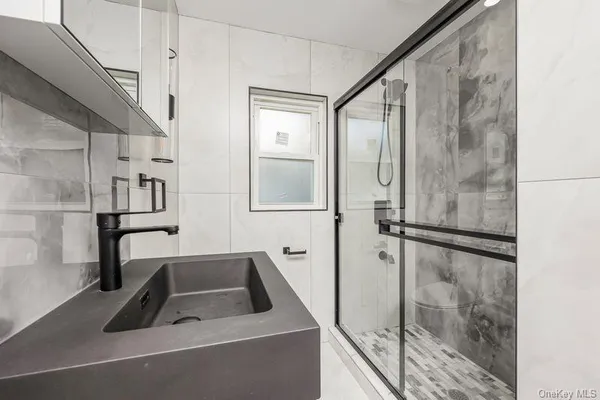 a bathroom with a sink a glass door and shower