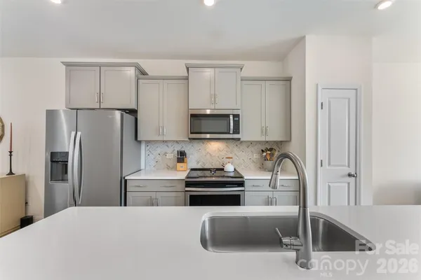 a kitchen with stainless steel appliances a refrigerator sink and microwave