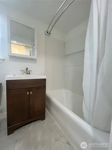 a bathroom with a sink a bathtub and a mirror