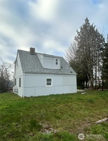 a front view of house with yard and trees in the background
