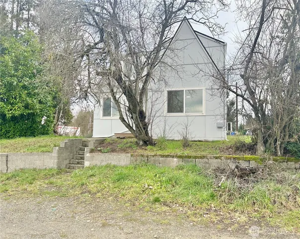 a view of a yard in front of a house with large trees