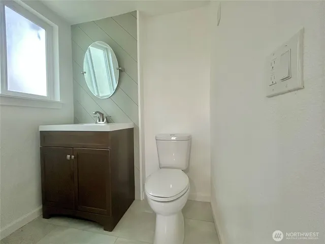 a bathroom with a toilet a sink and mirror