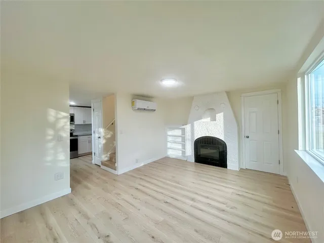 a view of a livingroom with wooden floor and staircase