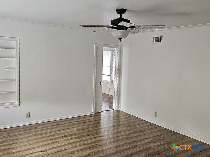608 3rd Street Cuero, TX 77954 - Photo 2 of 8 a view of empty room with wooden floor and fan