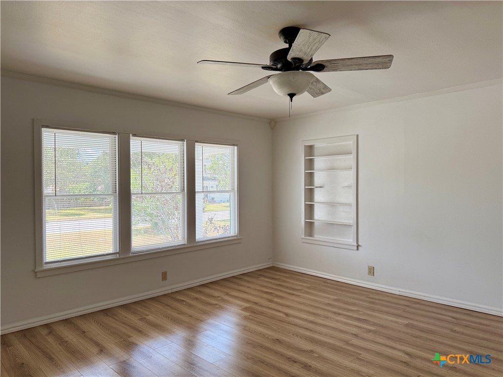 608 3rd Street Cuero, TX 77954 - Photo 3 of 8 a view of an empty room with wooden floor and a window