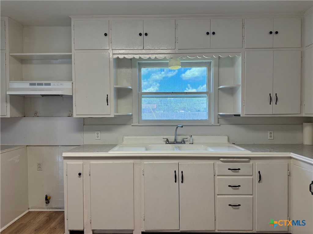 608 3rd Street Cuero, TX 77954 - Photo 4 of 8 a kitchen with white cabinets and white appliances