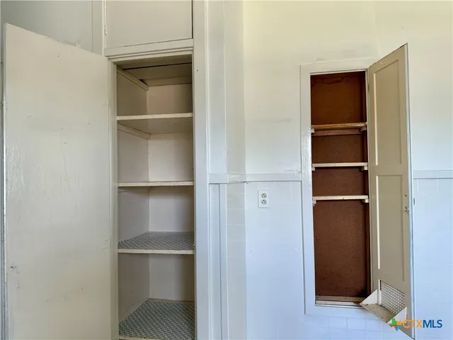 a walk in closet with empty racks