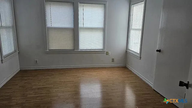 a view of a small space with wooden floor and a window