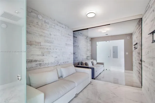 a living room with furniture and a glass door shower