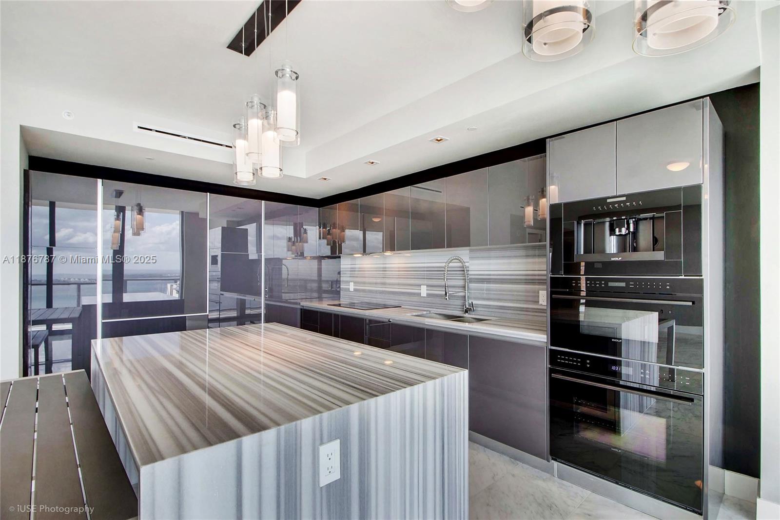 1451 Brickell Avenue, Unit 3102 Miami, FL 33131 - Photo 7 of 25 a kitchen with stainless steel appliances kitchen island granite countertop a refrigerator oven a sink dishwasher and white cabinets with wooden floor