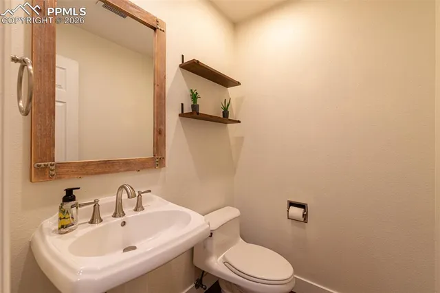 a bathroom with a sink a toilet and mirror