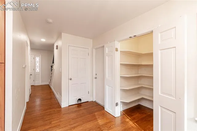 a view of a hallway with wooden floor