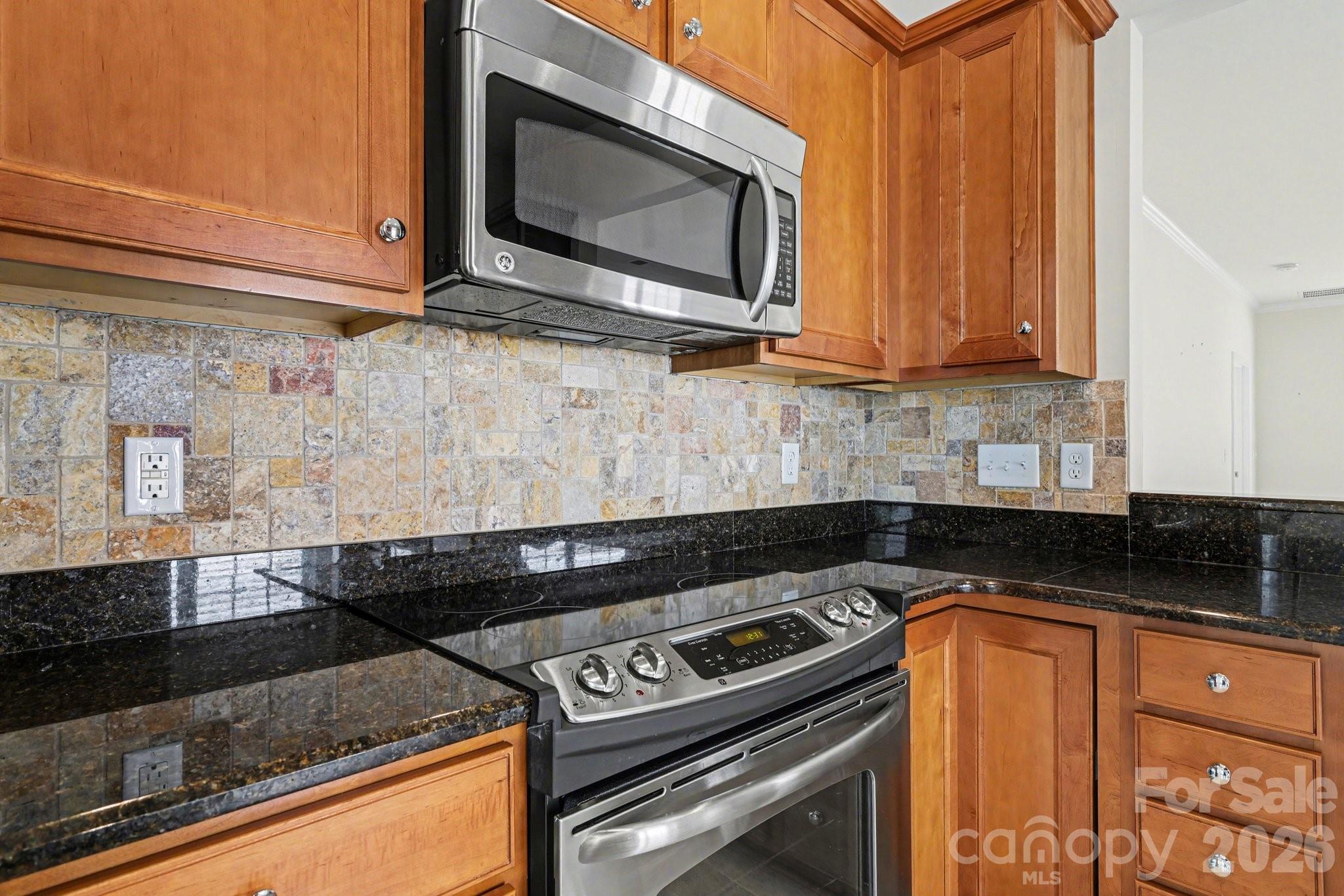 3918 Yosemite Way Fort Mill, SC 29707 - Photo 6 of 24 a kitchen with granite countertop a stove top oven microwave and cabinets