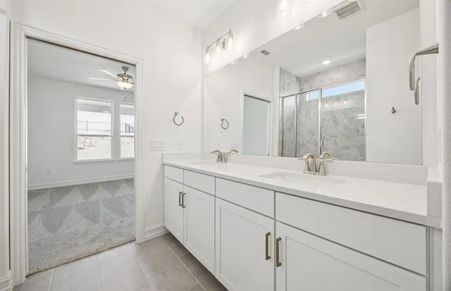 a bathroom with a double vanity sink and mirror with shower