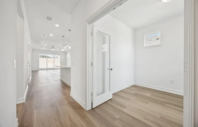 a view of a hallway with wooden floor