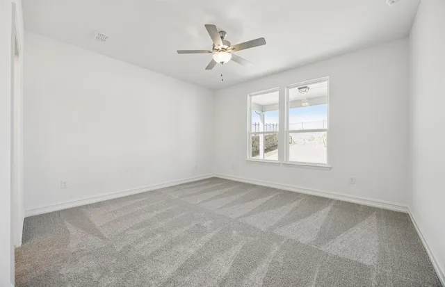 an empty room with a window and a ceiling fan