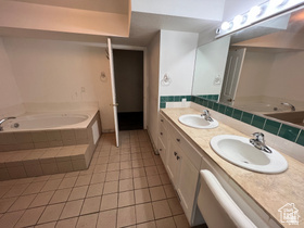 3013 North 100 West Provo, UT 84604 - Photo 4 of 18 Bathroom featuring a garden tub, double vanity, and light tile patterned floors
