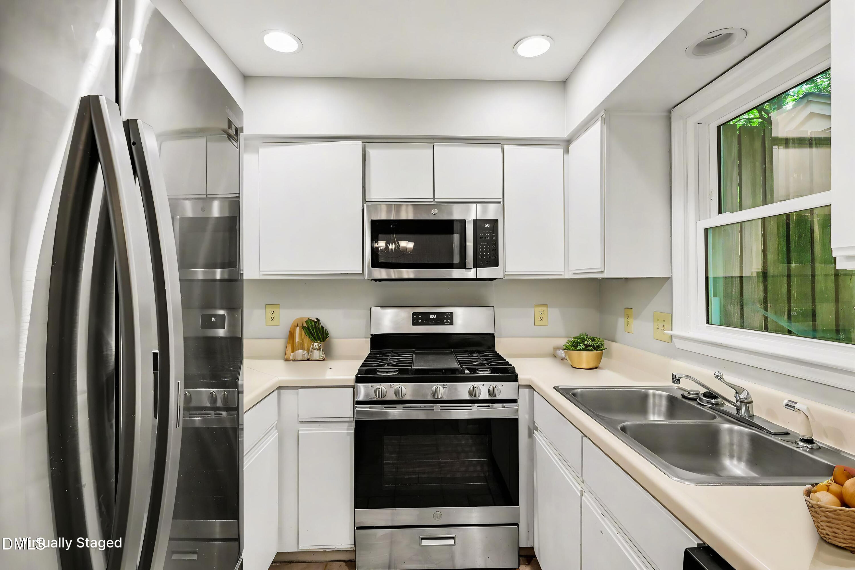 5645 Hamstead Crossing Raleigh, NC 27612 - Photo 3 of 35 a kitchen with stainless steel appliances a stove a sink and a microwave