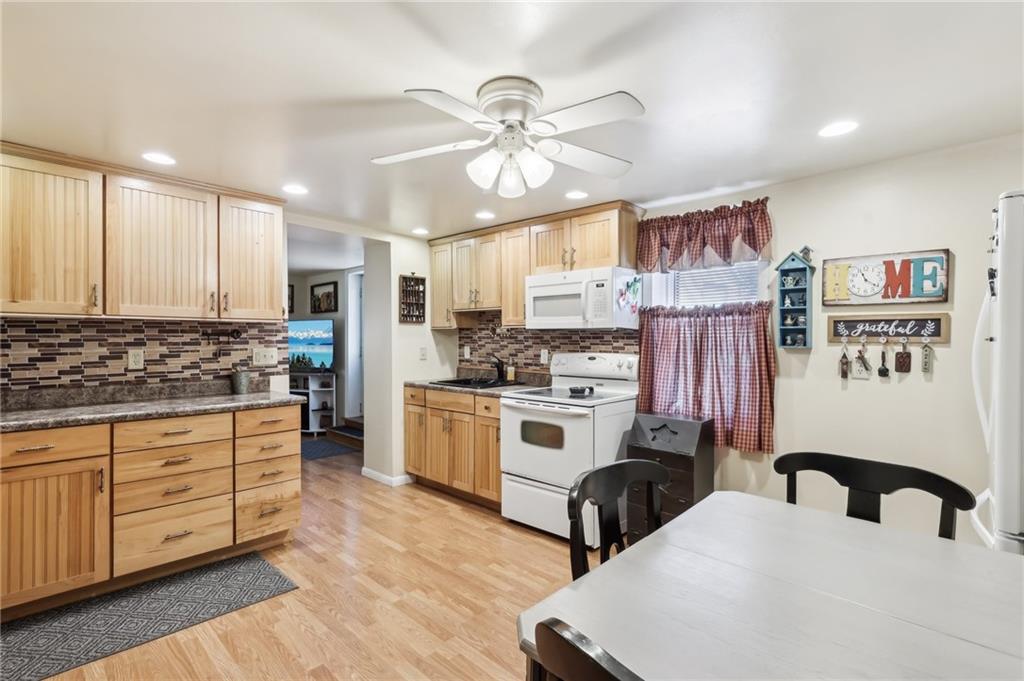 199 Latimer Avenue Strabane, PA 15363 - Photo 14 of 44 a kitchen with stainless steel appliances a stove a sink dishwasher and white cabinets with wooden floor