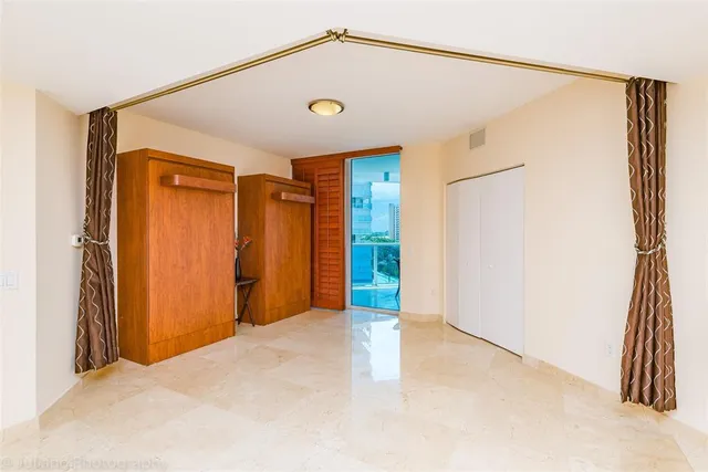 a view of a hallway with furniture and a refrigerator